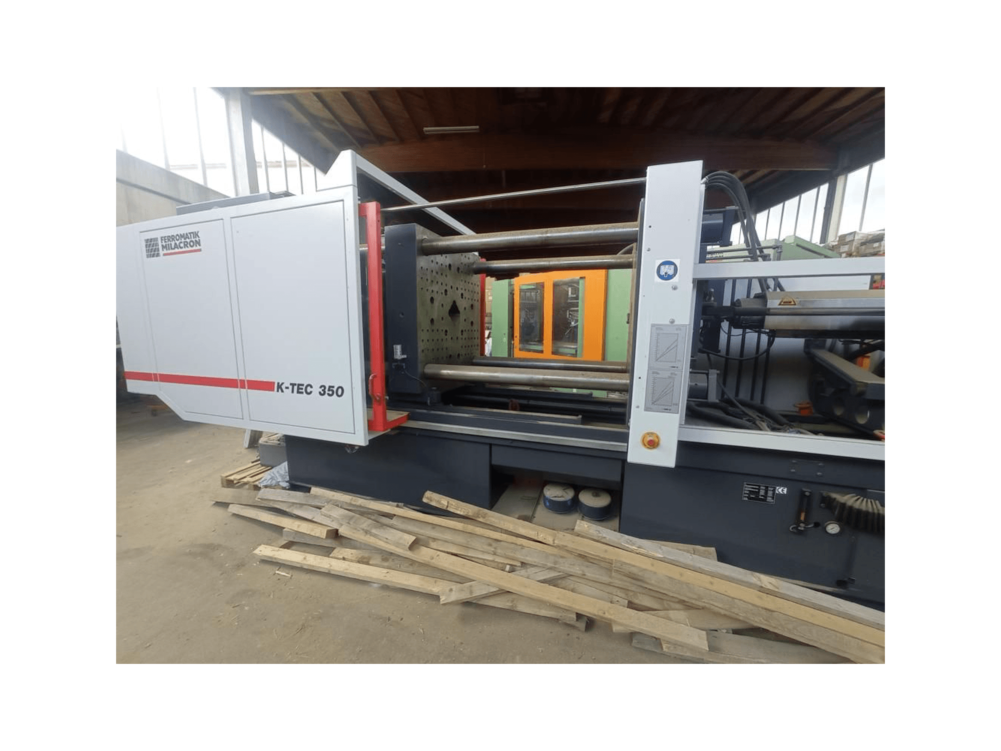 K-TEC 350 di Ferromatik Milacron, visto lateralmente, mostra i suoi complessi macchinari e controlli operativi.