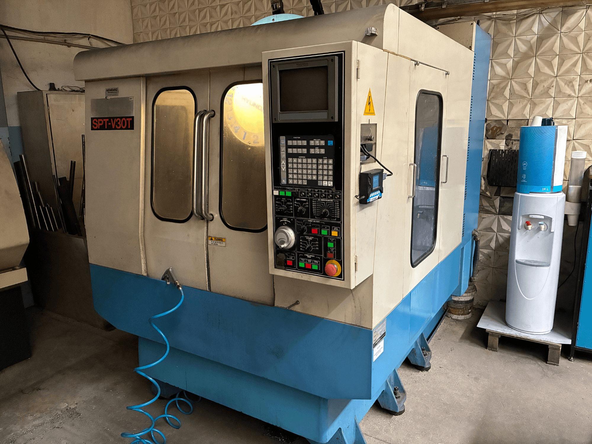 Fresatrice industriale SPT-V30T, vista frontale, con pannello di controllo, pulsanti e tubo flessibile blu.