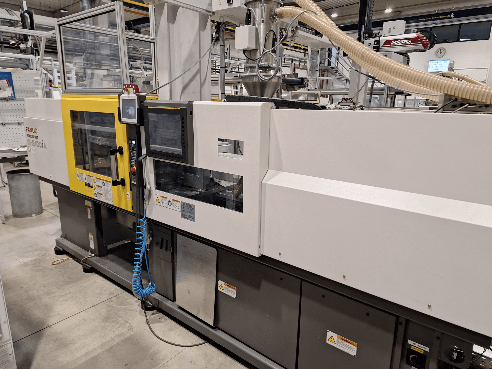 Macchina per lo stampaggio a iniezione FANUC Roboshot α-S300iA, vista frontale, con pannello di controllo e componenti industriali visibili.